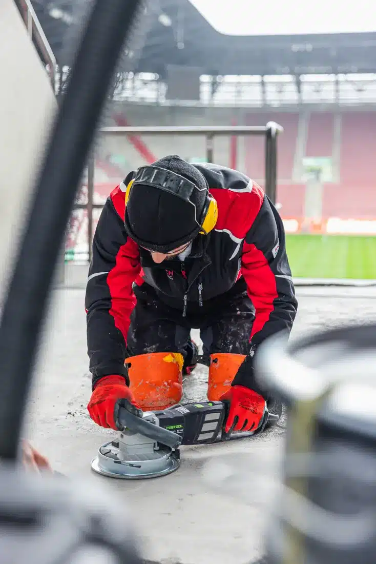 image_0330fe.jpg Resintech-Mitarbeiter bei der Bodenbearbeitung in der WWK Arena Augsburg mit einer Festool Schleifmaschine.
