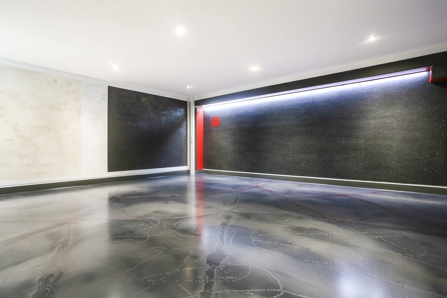 Exklusives Interior-Design: Dunkle Wandveredelung mit Lichtakzenten und ein glänzender Design-Harzboden in Marmor-Optik.