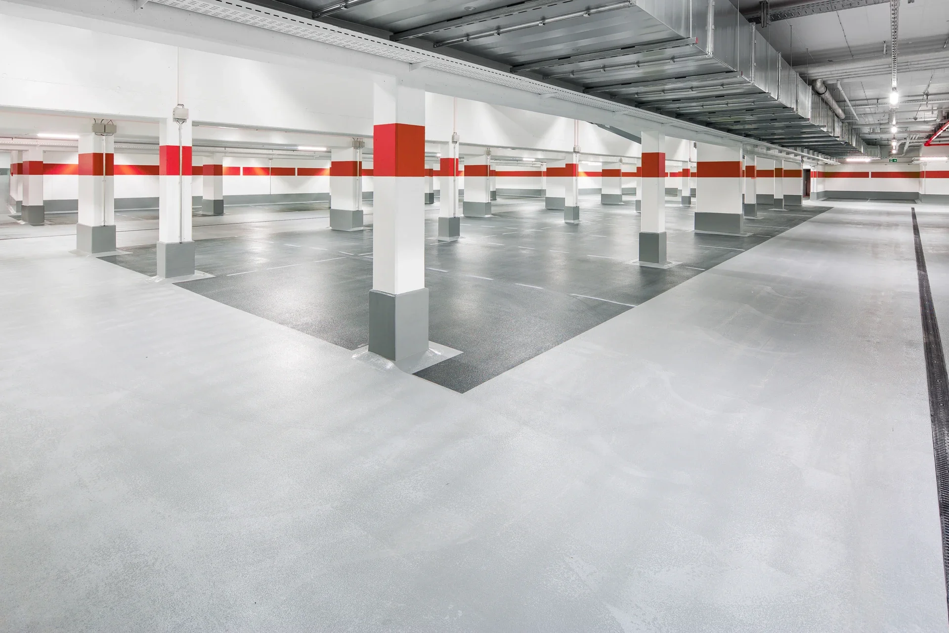 Übersicht eines fertiggestellten Tiefgaragenprojekts mit Fokus auf langlebiger OS-Beschichtung und klarem Leitsystem.