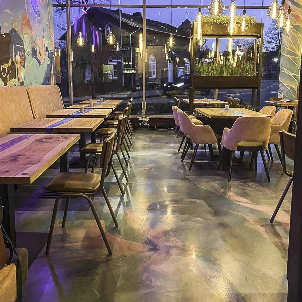 Gastronomie-Konzept mit künstlerisch veredeltem Designboden, dessen fließende Farbmuster perfekt mit dem Lichtkonzept harmonieren.
